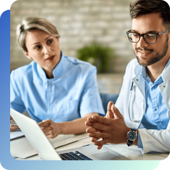 A woman and a man in a laboratory coat are talking in front of a laptop